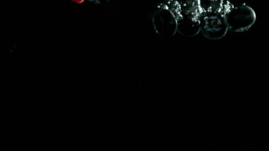 Düşen dutların süper yavaş çekimi siyah arkaplanda suya karışıyor. Yüksek hızlı sinema kamerası, 1000 fps..