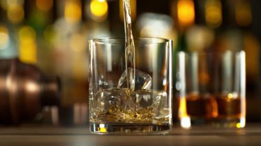 Super slow motion of pouring whiskey into glass. Filmed on high speed cinema camera, 1000 fps. Speed ramp effect.