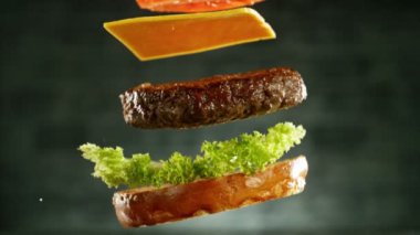 Çizburger parçalarını istiflemek için süper yavaş çekim. Kamera hareket halinde. Yüksek hızlı sinema kamerası, 1000 fps. Yüksek hızlı sinüs robotuna yerleştirilmiş.