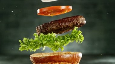 Çizburger parçalarını istiflemek için süper yavaş çekim. Kamera hareket halinde. Yüksek hızlı sinema kamerası, 1000 fps. Yüksek hızlı sinüs robotuna yerleştirilmiş.