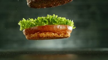 Çizburger parçalarını istiflemek için süper yavaş çekim. Kamera hareket halinde. Yüksek hızlı sinema kamerası, 1000 fps. Yüksek hızlı sinüs robotuna yerleştirilmiş.