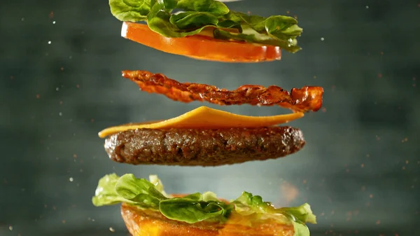 Чізбургер Літаючими Інгредієнтами Реалістичний Рух Заморожування Темно Сірий Фон Стіни — стокове фото