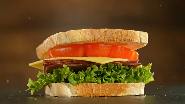 夹杂着生菜 西红柿 火腿和奶酪的三明治 放在黑石上 — 图库照片