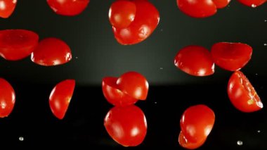 Siyah arka planda düşen domateslerin çok yavaş hareket etmesi. Yüksek hızlı sinema kamerası, 1000 fps. Kamera yüksek hızlı sinüs botuna yerleştirildi, nesneyi takip ediyor.