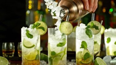 Super slow motion of preparing mojito drink with speed motion. Filmed on high speed cinema camera, 1000 fps, placed on high speed cine bot. Bar with bottles on background.