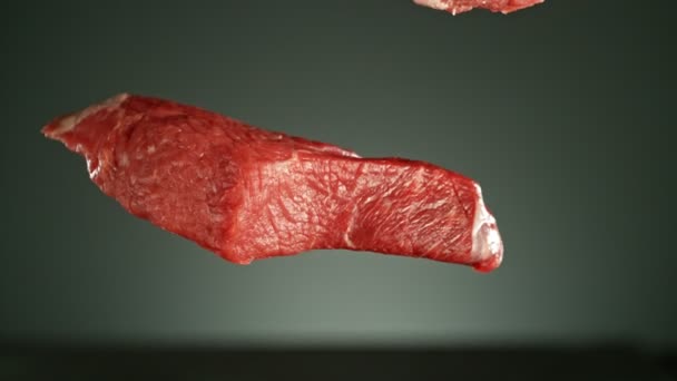 Létající Kousky Syrových Hovězích Steaků Kořením Padajícím Stůl Natočeno Vysokorychlostní — Stock video