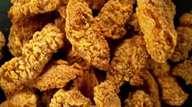 Siyah arka planda uçan kızarmış tavuk parçaları. Yüksek hızlı sinema kamerası, 1000 fps. Kamera yüksek hızlı sinüs robotuna yerleştirildi, hedefi takip ediyor..