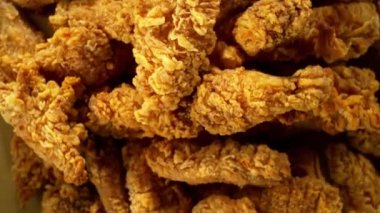 Sarı zemin üzerinde kızarmış tavuk parçaları uçuşan süper yavaş çekim. Yüksek hızlı sinema kamerası, 1000 fps. Kamera yüksek hızlı sinüs robotuna yerleştirildi, hedefi takip ediyor..