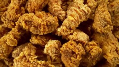 Sarı zemin üzerinde kızarmış tavuk parçaları uçuşan süper yavaş çekim. Yüksek hızlı sinema kamerası, 1000 fps. Kamera yüksek hızlı sinüs robotuna yerleştirildi, hedefi takip ediyor..