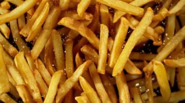 Siyah arka planda uçan patates kızartmalarının süper yavaş çekimi. Yüksek hızlı sinema kamerası, 1000 fps. Kamera yüksek hızlı sinüs robotuna yerleştirildi, hedefi takip ediyor..