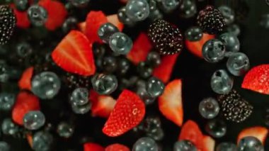 Havada dönen böğürtlenlerin süper yavaş çekimi, üst manzara. Yüksek hızlı sinema kamerası, 1000 fps. Hız rampası etkisi.