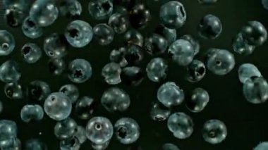 Havada dönen yaban mersinlerinin süper yavaş çekimi, üst manzara. Yüksek hızlı sinema kamerası, 1000 fps. Hız rampası etkisi.