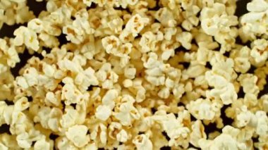 Havada dönen patlamış mısırın süper yavaş çekimi. Siyah arka planda izole edilmiş. Yüksek hızlı sinema kamerası, 1000 fps, yüksek hızlı sinüs botuna yerleştirilmiş, hedefi takip ediyor..