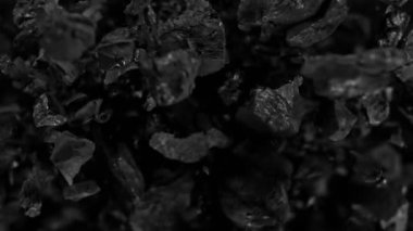 Siyah arka planda dönen kömür parçalarının süper yavaş çekimi. Yüksek hızlı sinema kamerası ile çekildi, 1000fps, yüksek hızlı sinüs robotuna yerleştirildi, hedefi takip ediyor. Hız rampası etkisi.