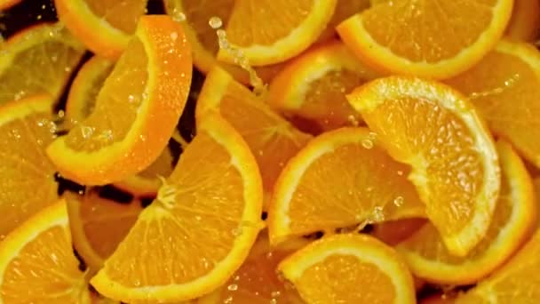 Super Pomalý Pohyb Létajících Oranžových Plátků Vodou Černém Pozadí Natočeno — Stock video