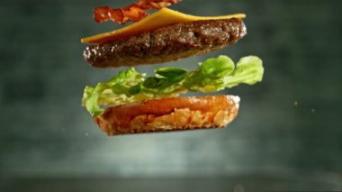 Çizburger parçalarını istiflemek için süper yavaş çekim. Kamera hareket halinde. Yüksek hızlı sinema kamerası, 1000 fps. Yüksek hızlı sinüs robotuna yerleştirilmiş.