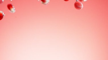 Nar parçalarının suya düşmesi çok yavaş bir hareket. Kırmızı arka planda izole edilmiş. Yüksek hızlı sinema kamerası, 1000fps.