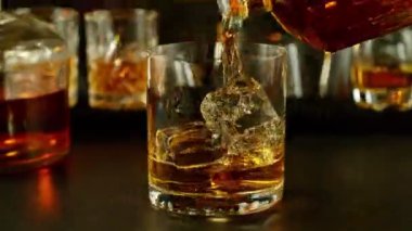 Buz küpünün viski içkisine dönüşmesi çok yavaş bir hareket, kamera hareketi. Yüksek hızlı sinema kamerası, 1000 fps. Hız rampası etkisi.