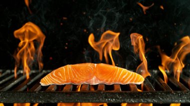 Çiğ somon biftekli ızgara ızgara. Siyah Arkaplanda Barbekü Ateş Ağı.