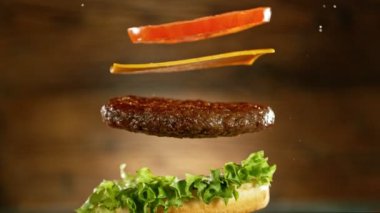 Çizburger parçalarını istiflemek için süper yavaş çekim. Kamera hareket halinde. Yüksek hızlı sinema kamerası, 1000 fps. Yüksek hızlı sinüs robotuna yerleştirilmiş.