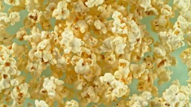 Havada dönen patlamış mısırın süper yavaş çekimi. Renkli arka planda izole edilmiş. Yüksek hızlı sinema kamerası, 1000 fps, yüksek hızlı sinüs botuna yerleştirilmiş, hedefi takip ediyor..