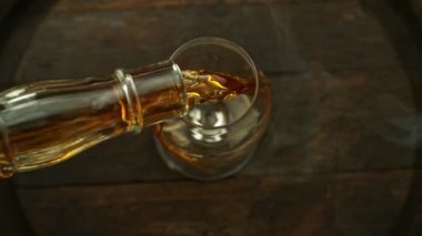 Süper yavaş çekimde konyak bardağa hızlı çekimle dökülüyor. Yüksek hızlı sinema kamerası, 1000 fps, yüksek hızlı sinüs botuna yerleştirilmiş..