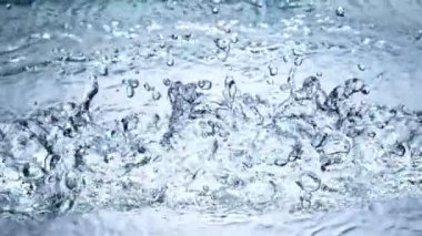 Suya çarpmanın çok yavaş bir etkisi var. Yakın plan. Yüksek hızlı sinema kamerası, 1000 fps. Hız rampası etkisi.