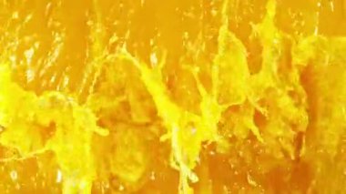 Süper Yavaş Sıçrayan Portakal Suyu Hareketi. High Speed Cinema Camera 'da çekildi, 1000 fps. Soyut Sıvı Arkaplan. Hız Rampası Efekti.
