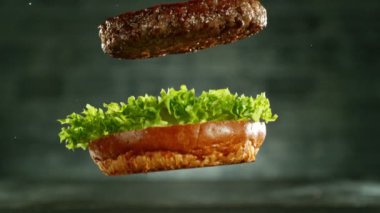 Hamburger parçalarını istiflemek için süper yavaş çekim. Kamera hareket halinde. Yüksek hızlı sinema kamerası, 1000 fps. Yüksek hızlı sinüs robotuna yerleştirilmiş.