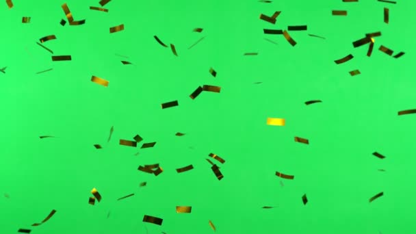 Super Slow Motion Flying Golden Confetti Isolated Green Background Filmed — Stock Video