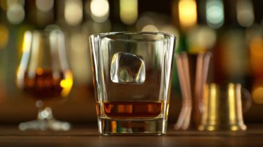 Buz küpünün viski içkisine düşmesi çok yavaş bir hareket. Yüksek hızlı sinema kamerası, 1000 fps..
