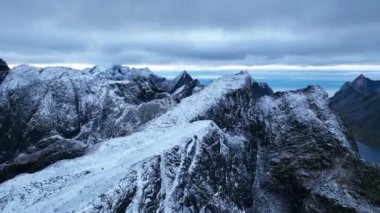 Norveç, Lofoten tepelerinin hava görüntüleri. Gün batımında güzel dev dağ manzaralı pürüzsüz uçuş görüntüleri..
