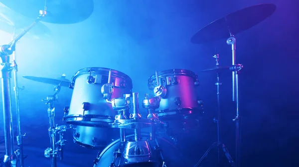 Drums Assembly with SMoke and Neon Lights. Dramatic Scene with Colored Neon Lights. Concert and Performance Theme.