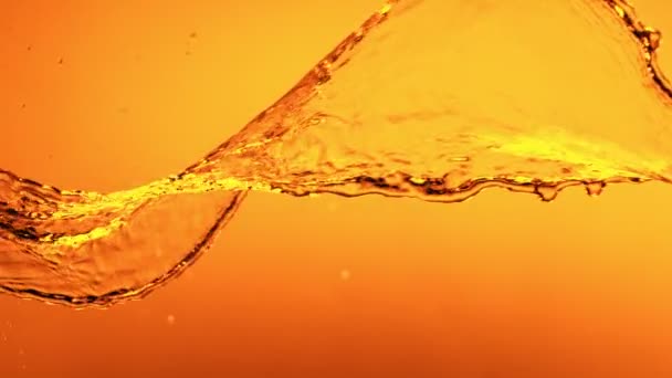 Super Slow Motion Spruzzare Liquido Dorato Rotante Isolato Sfondo Arancione — Video Stock
