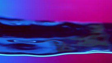 Neon Lights tarafından aydınlatılan Su Dalgalarının Süper Yavaş Hareketi. Yüksek Hız Sinema Kamerası, 1000 fp..