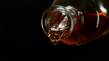 Şişeden Viski Doldurmanın Süper Yavaş Hareketi. Yüksek Hız Sinema Kamerası, 1000 Fps, Yüksek Hız Cine Bot 'a Yerleştirilmiş. Kamera Sıvı Akımı Takip Ediyor. Kara Arkaplanda İzole Edilmiş.