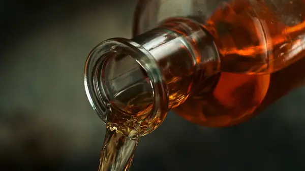 Bottle of Whiskey with Pouring Liquid. Detail of Whiskey Bottle, Beverages Background.