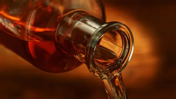 Bottle of Whiskey with Pouring Liquid. Detail of Whiskey Bottle, Beverages Background.