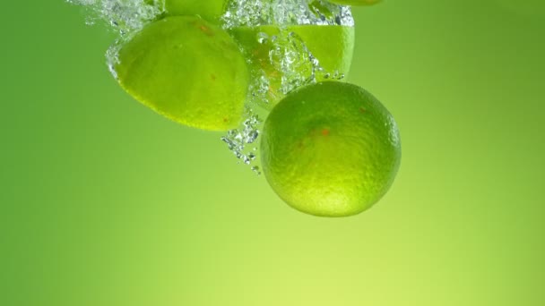 Super Slow Motion Falling Pile Limes Water Izolowane Zielonym Tle — Wideo stockowe