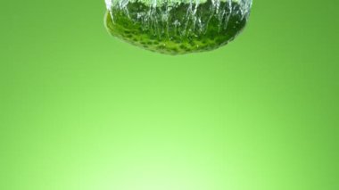 Düşen Salatalığın Süper Yavaş Hareketi. Renkli Arkaplanda Suya Atlama. Yüksek Hız Sinema Kamerası, 1000 fp..