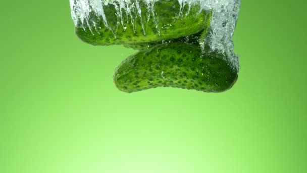 落叶黄瓜的超级慢动作 在彩色背景上洒入水中 在高速电影摄影机上拍摄 1000 Fps — 图库视频影像