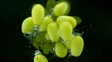 Düşen Şarap Üzümlerinin Siyah Arkaplanda Suya Düşmesi Süper Yavaş Hareketi. Yüksek Hız Sinema Kamerası, 1000 fp..