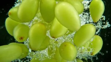 Düşen Şarap Üzümlerinin Siyah Arkaplanda Suya Düşmesi Süper Yavaş Hareketi. High Speed Cinema Camera 'da çekildi, 1000 fps. Hız Rampası Efekti.