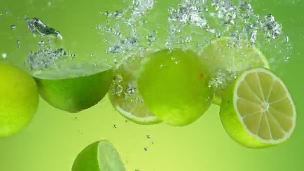 Super Slow Motion Falling Limes Water Aislado Sobre Fondo Verde — Vídeos de Stock