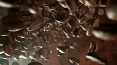 Kahverengi Arkaplan 'da, Süper Yavaş Düşen Kahve Fasulyesi Hareketi izole edildi. Macro Shot, Smoke on Background. High Speed Cinema Camera 'da çekildi, 1000 fps. Hız Rampası Efekti.