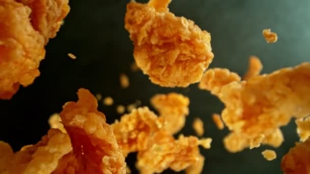 Super Zeitlupe Von Flying Fried Chicken Piecers Auf Schwarzem Hintergrund — Stockvideo