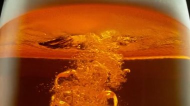 Süper yavaş çekimde makro bardakta bira, yakın çekim. Yüksek hızlı sinema kamerası, 1000 fps..