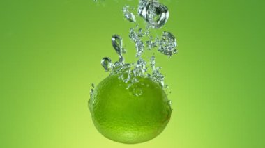 Yeşil arka planda izole edilmiş, suya düşen limonatanın süper yavaş hareketi. High Speed Cinema Camera 'da çekildi, 1000 fps. Hız Rampası Efekti.