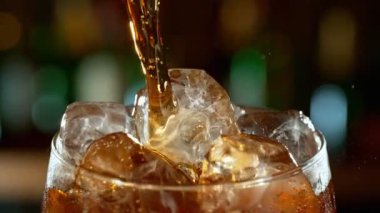 Kolayı hızlı çekimle bardağa doldurmanın süper yavaş bir yolu. Yüksek hızlı sinema kamerası, 1000 fps. Yüksek hızlı sinüs robotuna yerleştirilmiş. Arka planda şişe olan bar.