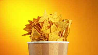 Flying Fried Tortilla Chips 'in Kova' dan Süper Yavaş Hareketi. Renkli Arka plan 'da izole edilmiş. Yüksek Hız Sinema Kamerası, 1000 fp..